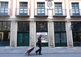 Un hombre camina frente a un bloque de viviendas turísticas en la calle Platerías.