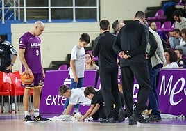 Dos chicos de la cantera se afanan para secar la zona más encharcada, en una de las esquinas.