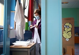 Una enfermera prepara una prueba sanitaria en un colegio.