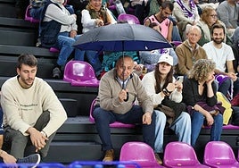 Un aficionado se protege con un paraguas de las goteras de Pisuerga.