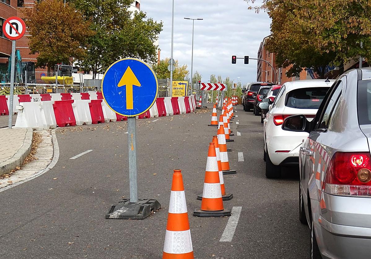 Imagen principal - Arriba, retenciones en el acceso a Parquesol por Ciudad de la Habana. Debajo, a la izquierda, el vial abierto de salida del barrio en Ciudad de la Habana, A la derecha, pasarela provisional para peatones por las obras en Juan García Hortelano.