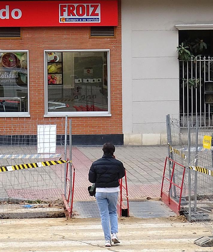 Imagen secundaria 2 - Arriba, retenciones en el acceso a Parquesol por Ciudad de la Habana. Debajo, a la izquierda, el vial abierto de salida del barrio en Ciudad de la Habana, A la derecha, pasarela provisional para peatones por las obras en Juan García Hortelano.