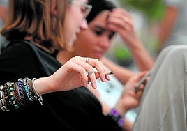 Una joven fuma en las inmediaciones de un colegio.