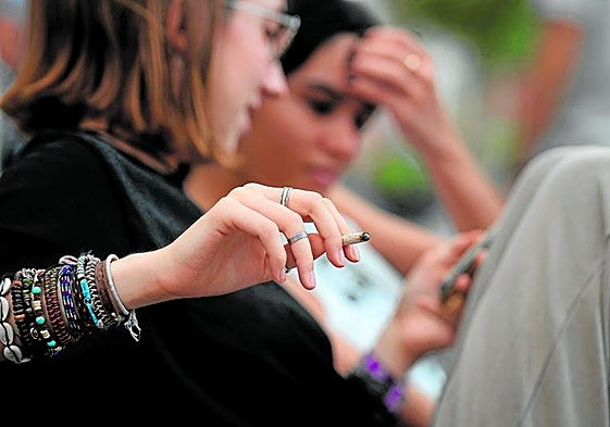Una joven fuma en las inmediaciones de un colegio.