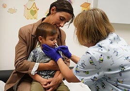 Una enfermera administra la vacuna de la gripe, en este caso intranasal, a un niño.