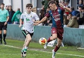 Diego Campo controla el balón perseguido por un jugador del Rayo Cantabria.