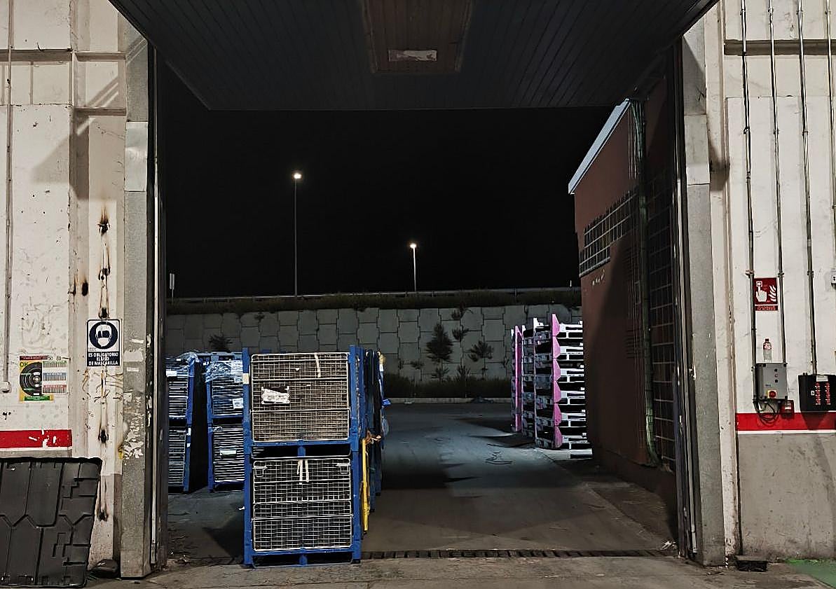 Imagen principal - Portón sin cortina de protección, barrizal de palomina y residuos en el suelo junto a una manguera.