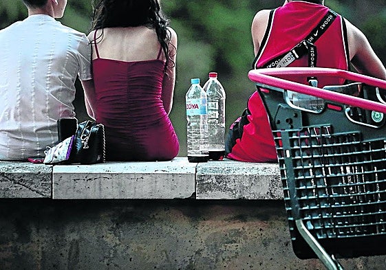 Jóvenes con botellas de calimocho en el espigón de la playa de las Moreras.