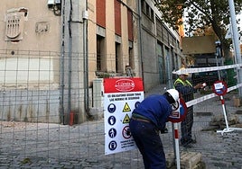 Obreros colocan señales y precintan el perímetro del edifico de los antiguos bomberos de Segovia, este miércoles.