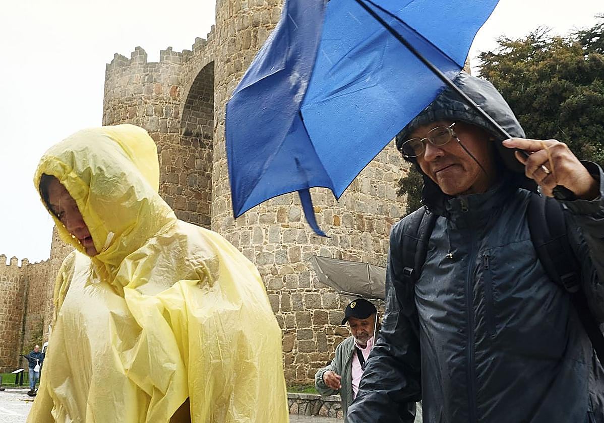 Viandantes se protegen de la lluvia en Ávila capital este jueves.