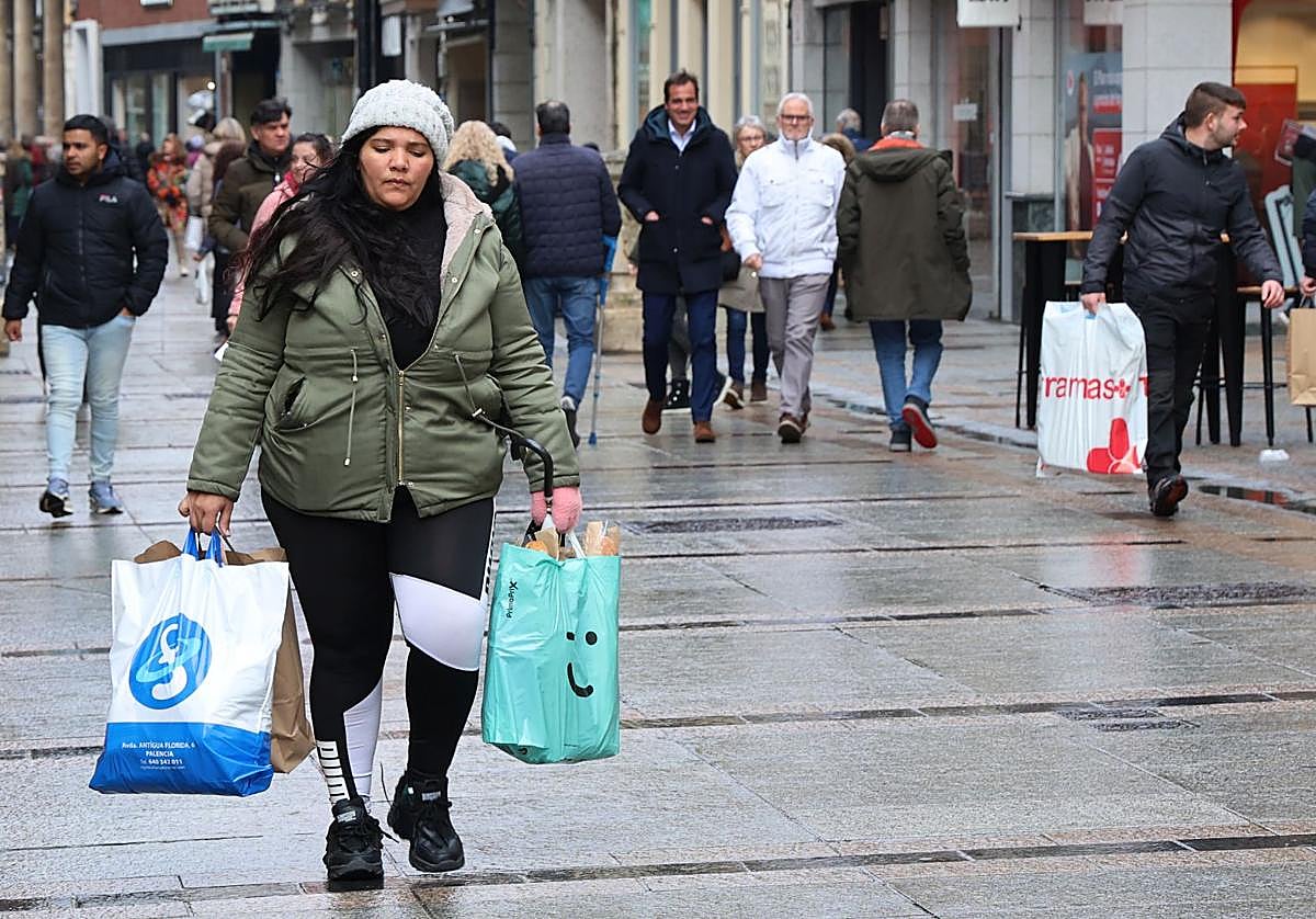 Viandantes por la Calle Mayor con bolsas de distinstos comercios.