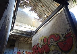 Grafitis en el interior de la nave de la antigua azucarera Santa Victoria, cuya cubierta presenta numerosos agujeros, a la que se puede acceder por un boquete abierto en el muro.