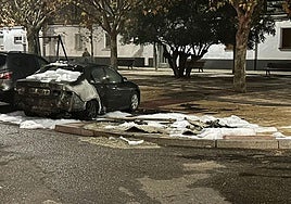 Coche dañado por el incendio con los restos de espuma tras la intervención de los bomberos en Amor de Dios.