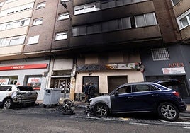 Destrozos tras los incendios en Doctor Esquerdo, con vehículos dañados y una fachada ennegrecida.