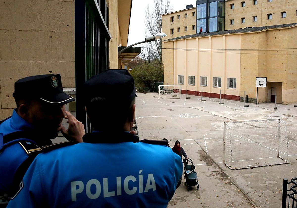 Agentes de la Policía Local de Segovia y al fondo los operarios en el tejado del edificio en obras al otro lado del patio de La Aneja.