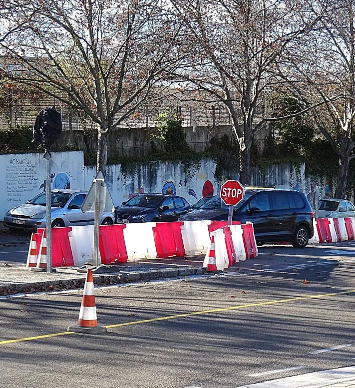 Imagen secundaria 2 - Arriba, el cartel que advierte de que pasan vehículos en los dos sentidos ante el colegio Francisco Pino. Debajo, a la izquierda, un coche dando la vuelta para salir del tramo cortado de Hernando de Acuña. Debajo, los separadores que indican el corte en la parte alta de la calle.