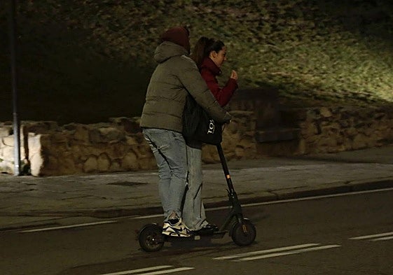 Dos jóvenes circulan sobre un patinete eléctrico
