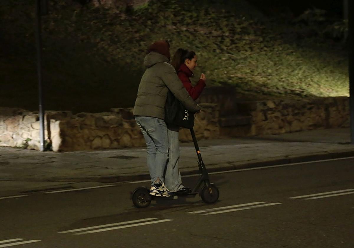 Dos jóvenes circulan sobre un patinete eléctrico