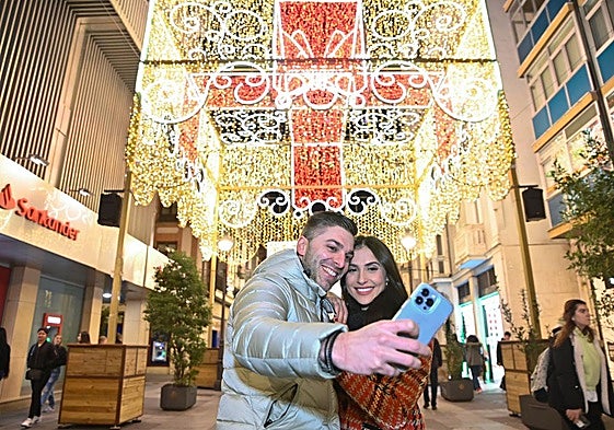 Una pareja se hace un selfie con la iluminación navideña de la calle Santiago en años anteriores.
