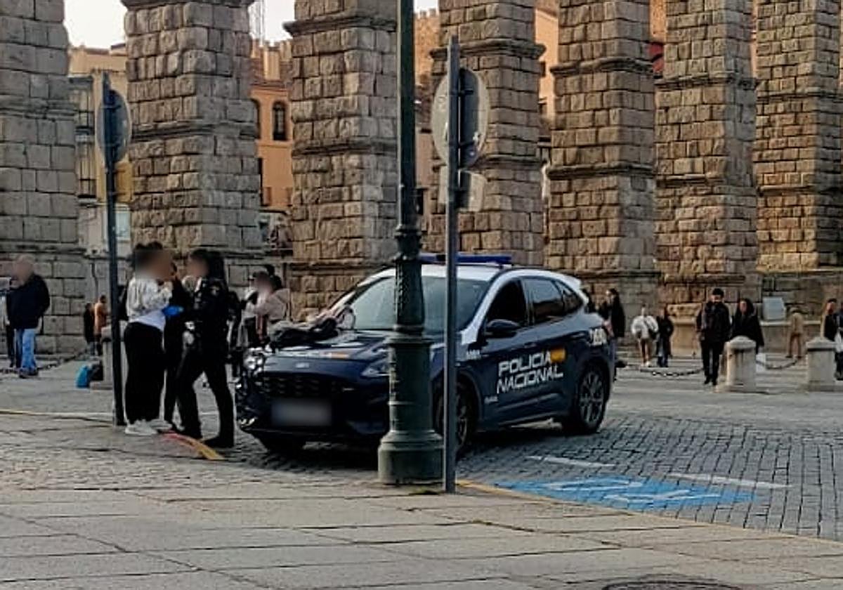 Patrulla de la Policía Nacional identifica a dos personas junto al Acueducto de Segovia.
