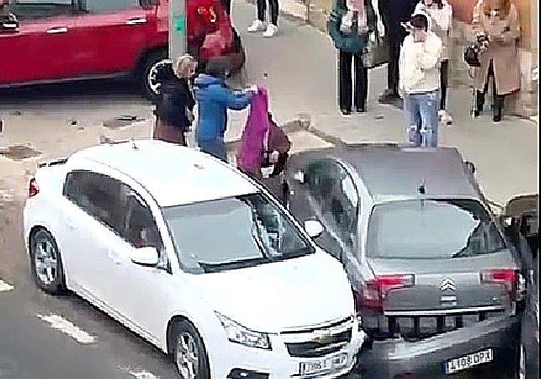 Vecinos y allegados cubren el cuerpo de la víctima junto a los coches implicados en el siniestro ocurrido en la travesía de Rioseco.