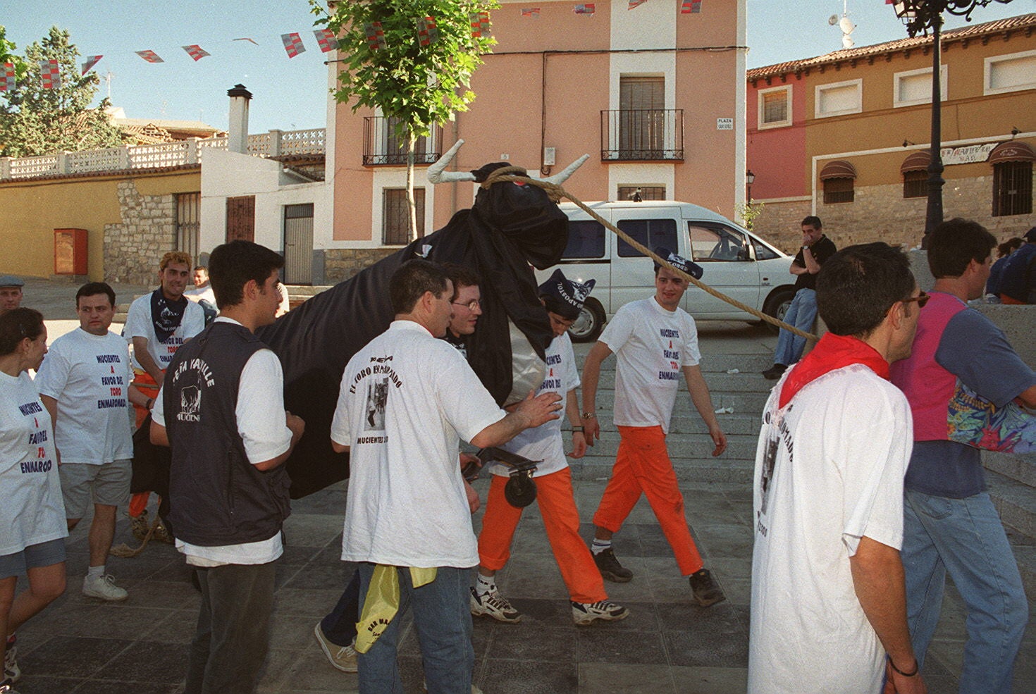 Varios jóvenes corren junto al toro de hierro fabricado por los peñistas en Mucientes. 1 de julio de 2000.