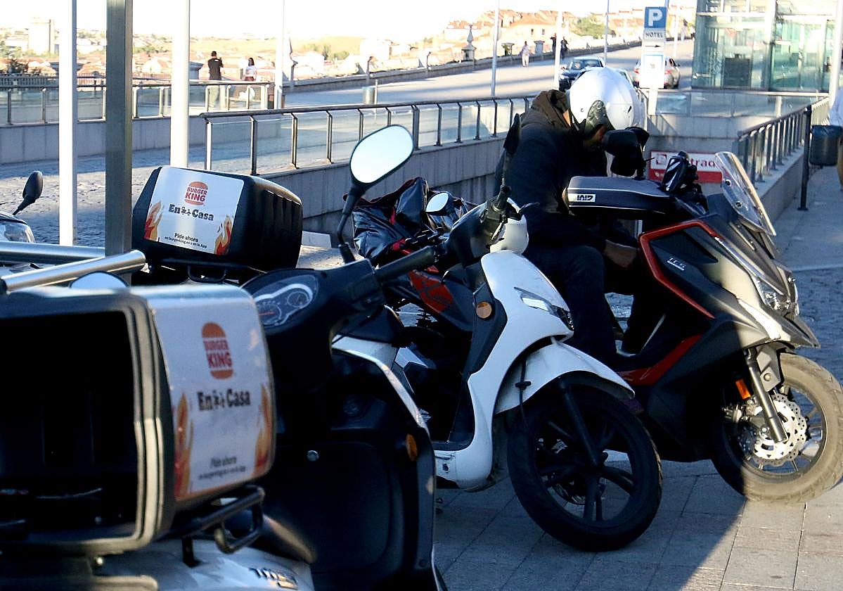 Motos usadas para el servicio de comida a domicilio aparcadas en Segovia.