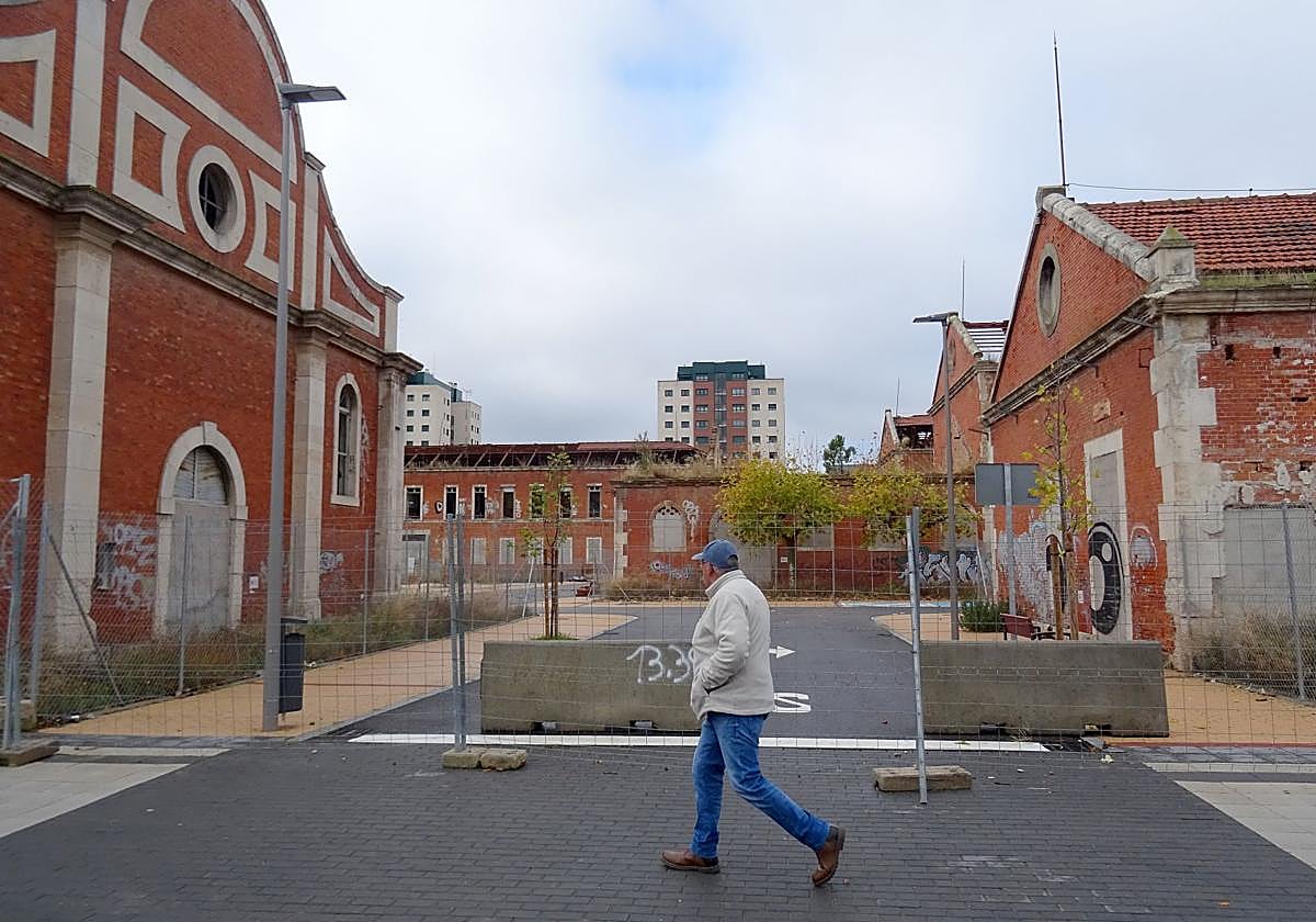 Un hombre pasa ante las vallas y bloque de hormigón que cierran la entrada desde la calle Bartolomé de las Casas al entramado de callejuelas del antiguo cuartel Conde Ansúrez.