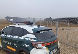 Un vehículo de la Guardia Civil junto a una planta fotovoltaica.