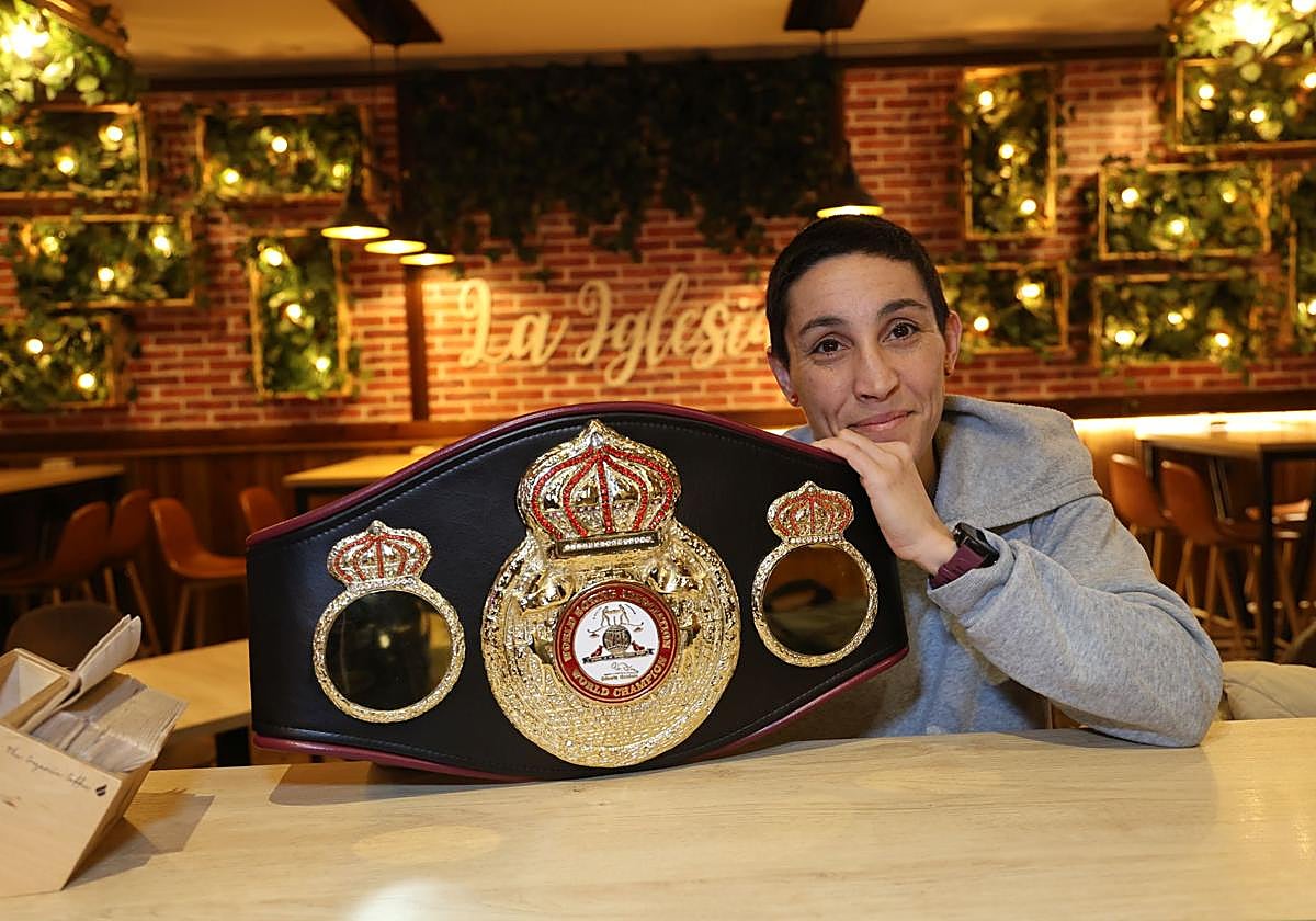 La boxeadora vallisoletana Isabel Rivero posa con su cinturón de campeona del mundo en peso átomo en el bar La Iglesia.