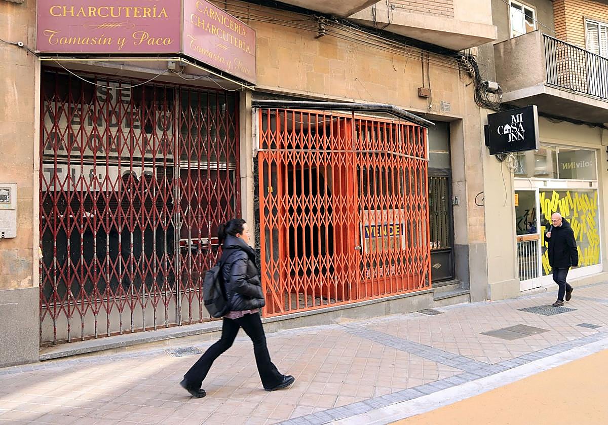 Transeúntes pasan por delante de dos locales comerciales cerrados en Blanca de Silos.