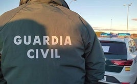 Imagen de archivo de un agente de la Guardia Civil junto a su coche.