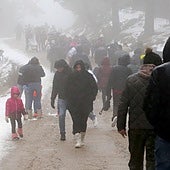 Decenas de personas pasean por el entorno del puerto de Navacerrada este sábado.