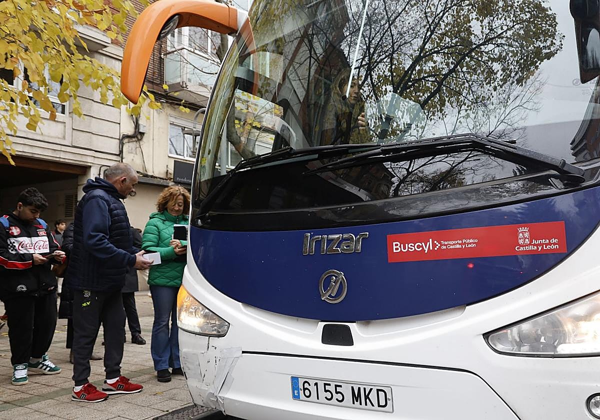 Varias personas esperan turno en Palencia para subir a un autobús.