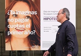 Un hombre camina frente a un banco que anuncia sus hipotecas en Valladolid, en una imagen de archivo.