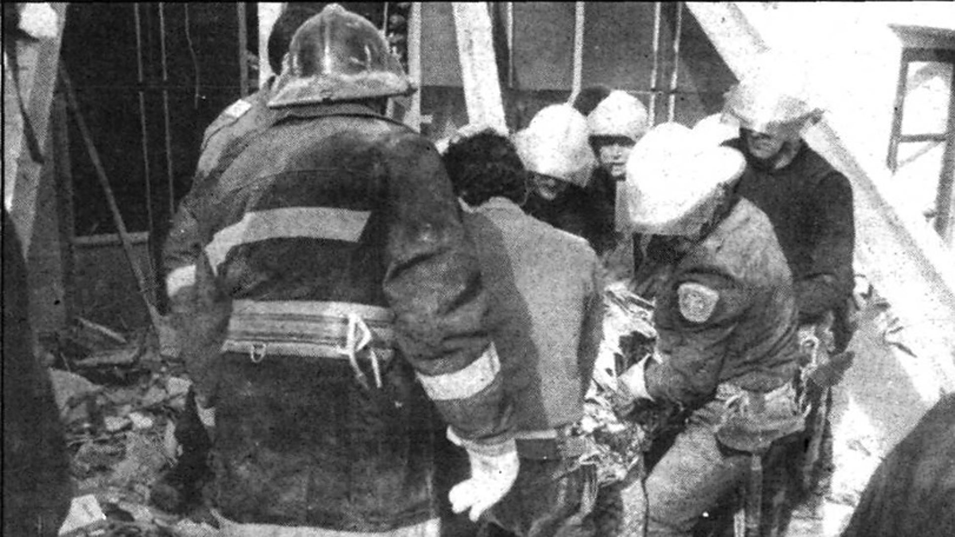 Momento en el que los bomberos rescatan el cadáver del hombre sepultado por el derrumbe en la calle Luna, en 1990.