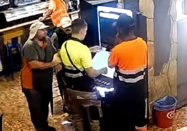 Cuatro sospechosos rodean la tragaperras asaltada del bar Suances para coger uno de los billetes expulsado, mientras un quinto, en la barra, distrae a la camarera.