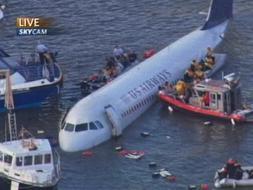 Las fuerzas de seguridad intentan rescatar a los tripulantes del avión que flota en el río Hudson. /Ap