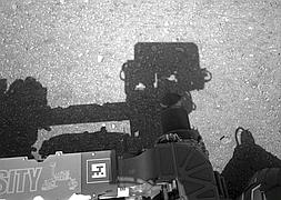 Primera imagen de la sombra del explorador arriba con el mástil al centro proyectada sobre Marte. / NASA