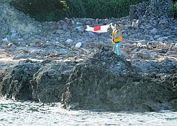 Un activista nipón coloca una bandera de Japón en una de las islas. / Antoine Bouthier (Afp)