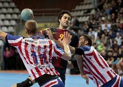 Raúl Entrerríos intenta avanzar ante la defensa de dos jugadores del Atlético./Salvador Sas (Efe)