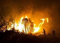 Dos bomberos trabajan en la extinción del incendio de Ribeira. / Óscar Corral (Efe)