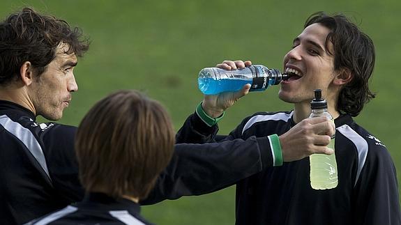 Futbolistas toman una bebida isotónica.