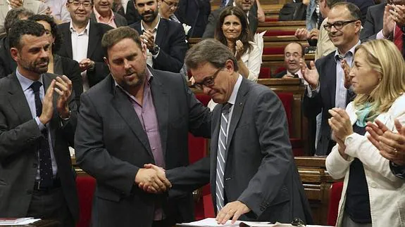 El presidente de la Generalitat, Artur Mas (c), estrecha la mano del lider de ERC, Oriol Junqueras (2i) 