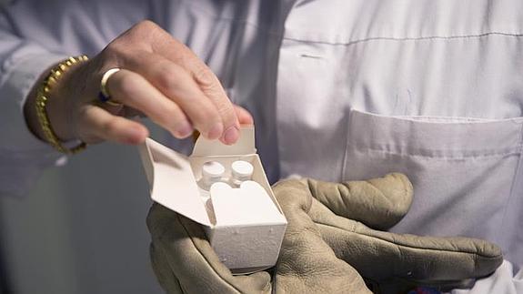 Una empleada comprueba un paquete de una vacuna experimental contra el ébola llamada VSE-EBOV