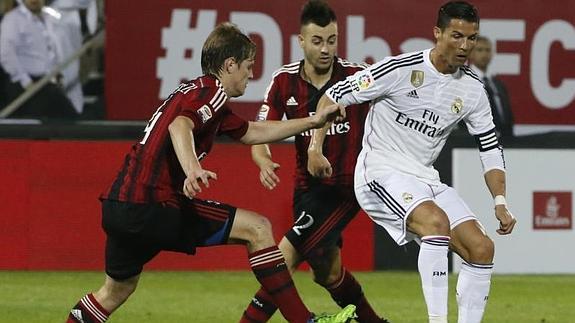 Cristiano (d) presionado por dos jugadores del Milan. 