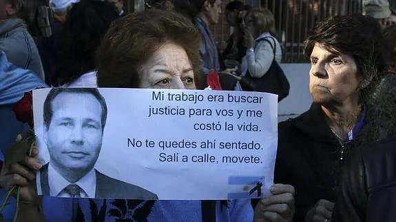 Una mujer sujeta un cartel con la cara de Nisman