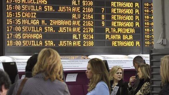 Viajeros esperan al tren en Atocha. 