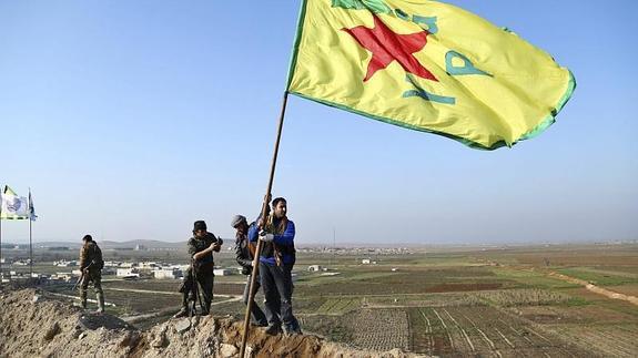 Varios miembros de las Unidades de Protección del Pueblo Kurdo (YPG) celebran su victoria en la ciudad de Kobani.