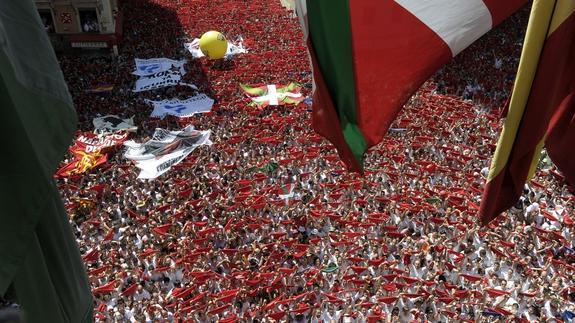 Miles de personas lanzan el tradicional "pañuelico" rojo en la Plaza del Ayuntamiento. 
